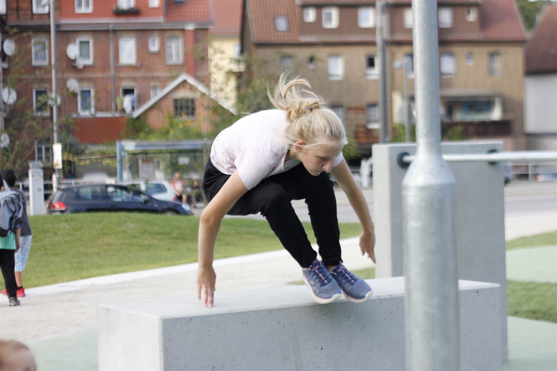 Traceurin springt über ein Hindernis beim Parkour-Training